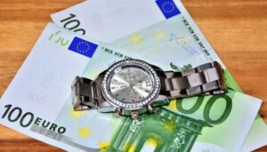 billetes de 100 euros y reloj de tiempo