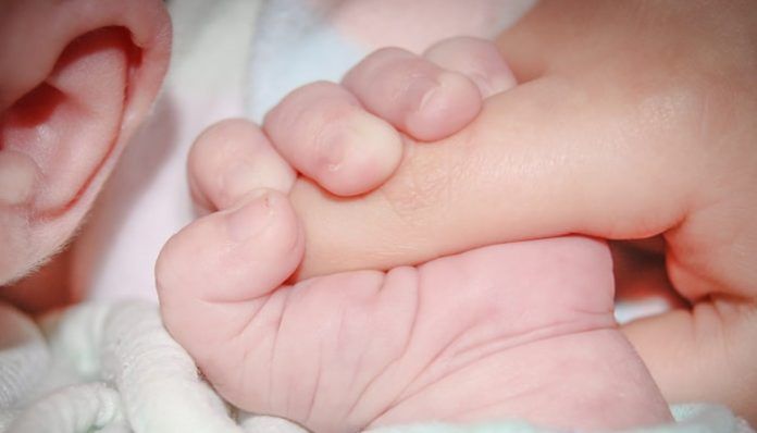 Bebé agarrado a la mano de su madre