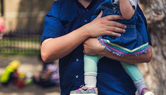 Un padre con su hija en brazos