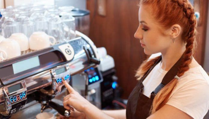 Camarera trabajando con la máquina de café