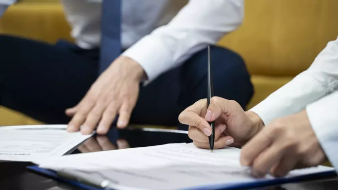 Empresarios firmando el cambio de titularidad de la empresa