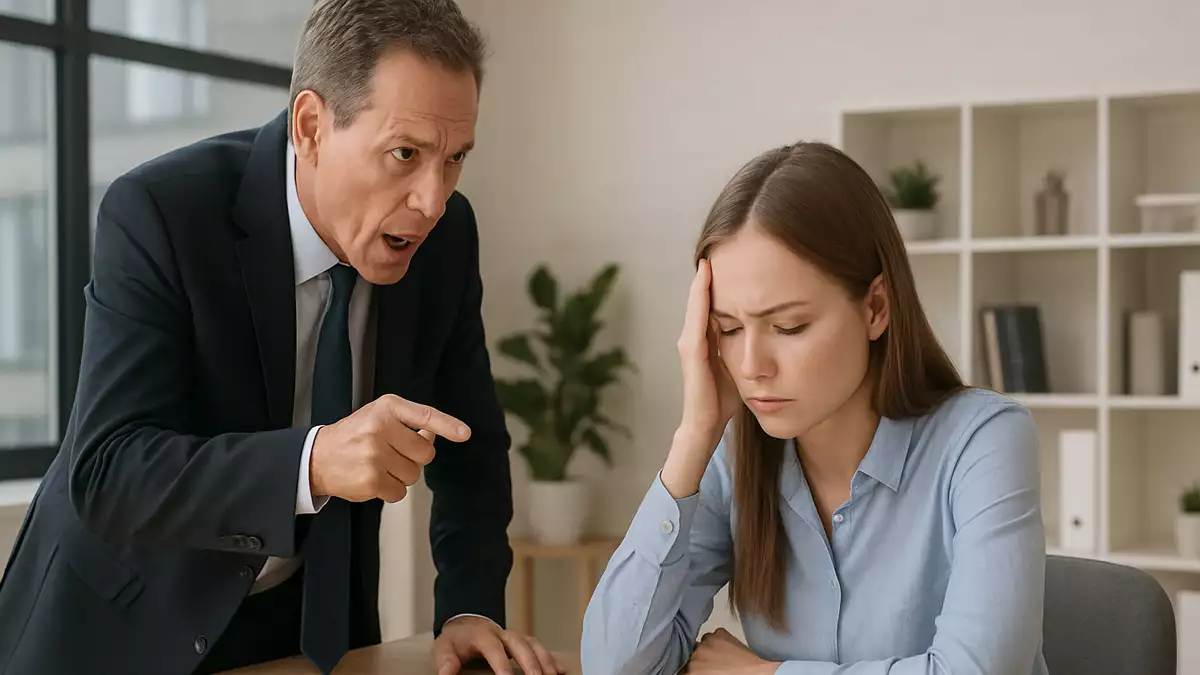 Supervisor señalando a una empleada visiblemente angustiada durante una discusión en la oficina