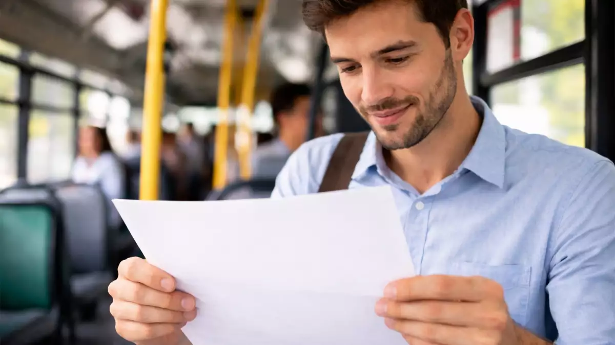 Trabajador desplazándose al trabajo mientras revisa un documento relacionado con el plus de transporte