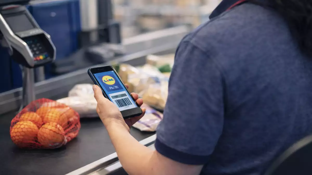 Cajera de Lidl utilizando móvil