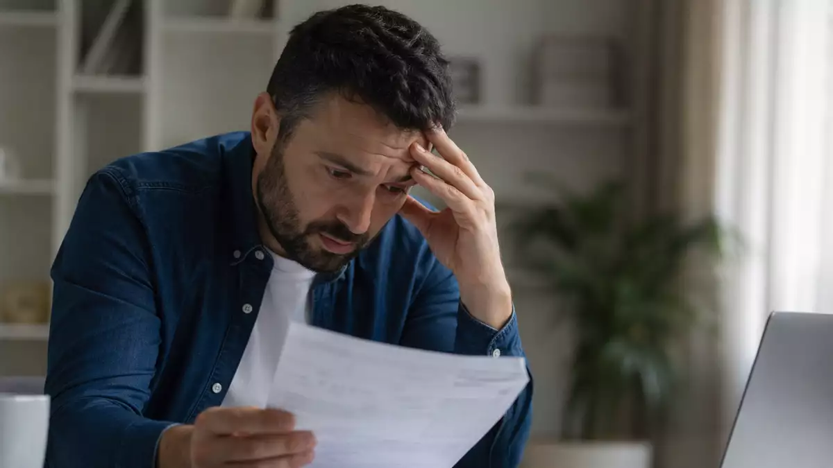 Trabajador preocupado revisando nómina con altos impuestos en España