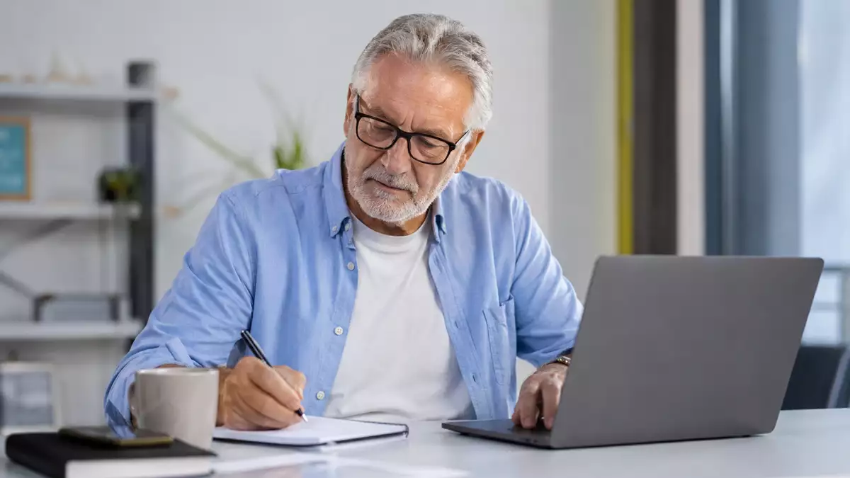 Persona jubilada trabajando desde casa como autónomo mientras mantiene parte de la pensión