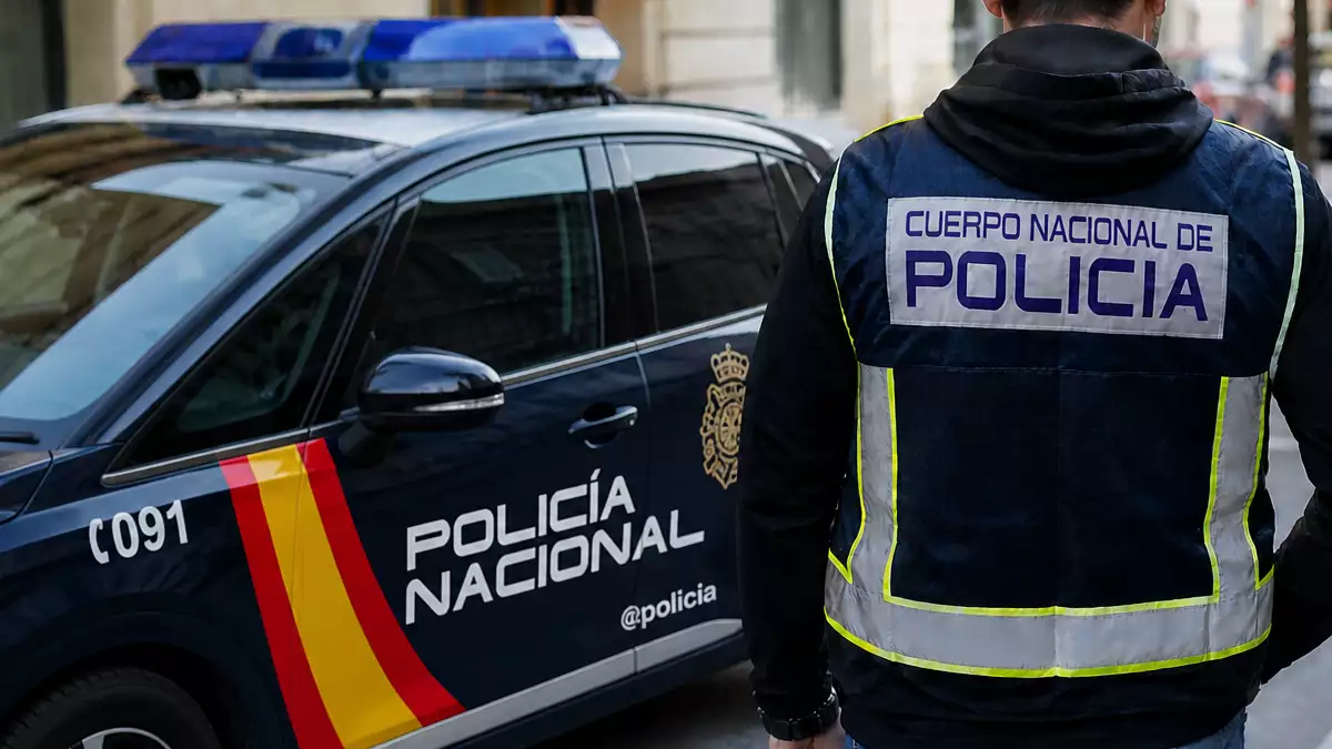 Agente de la Policía Nacional de paisano junto a un coche oficial en una imagen generada con inteligencia artificial