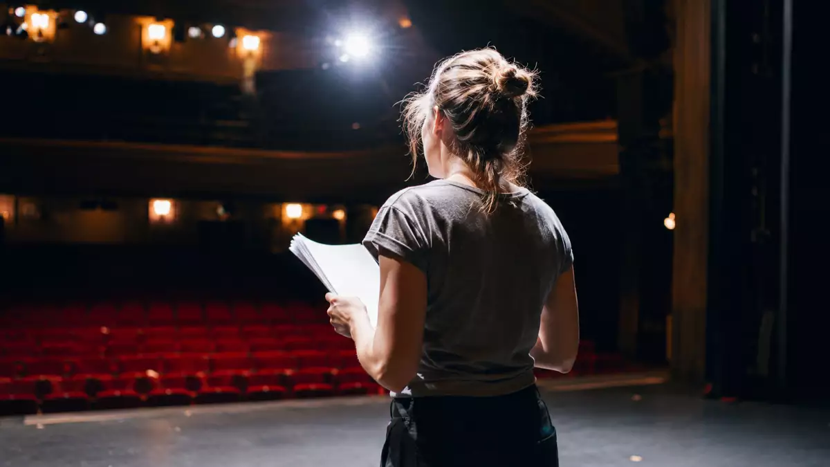 Mujer actuando en un escenario de teatro durante un ensayo