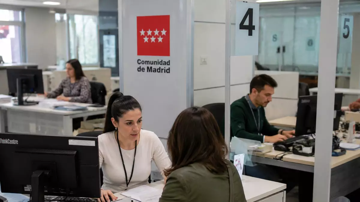 Funcionarios de la Administración General de la Comunidad de Madrid atendiendo a ciudadanos en una oficina pública