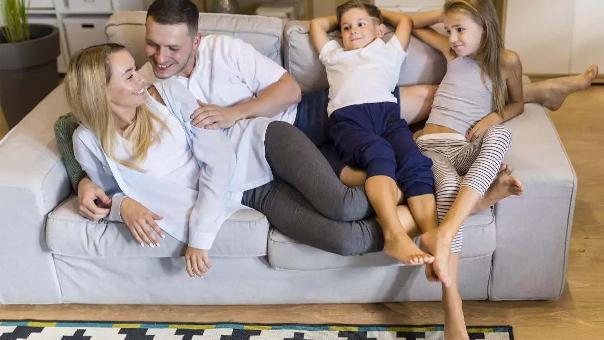 Familia feliz en el sofá de su casa