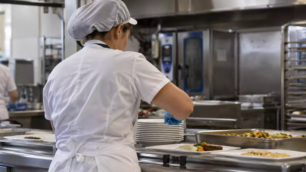 Recreación con IA de una trabajadora como auxiliar de cocina de un centro de salud